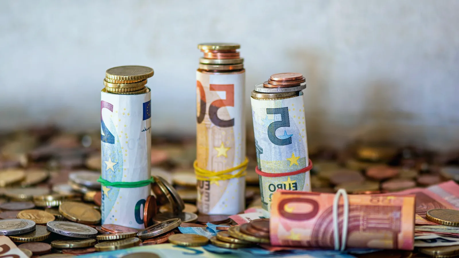 How to invest money from savings — rolled euro banknotes and coins